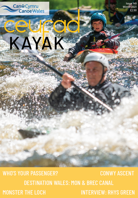 A man is paddling a kayak in a river.
