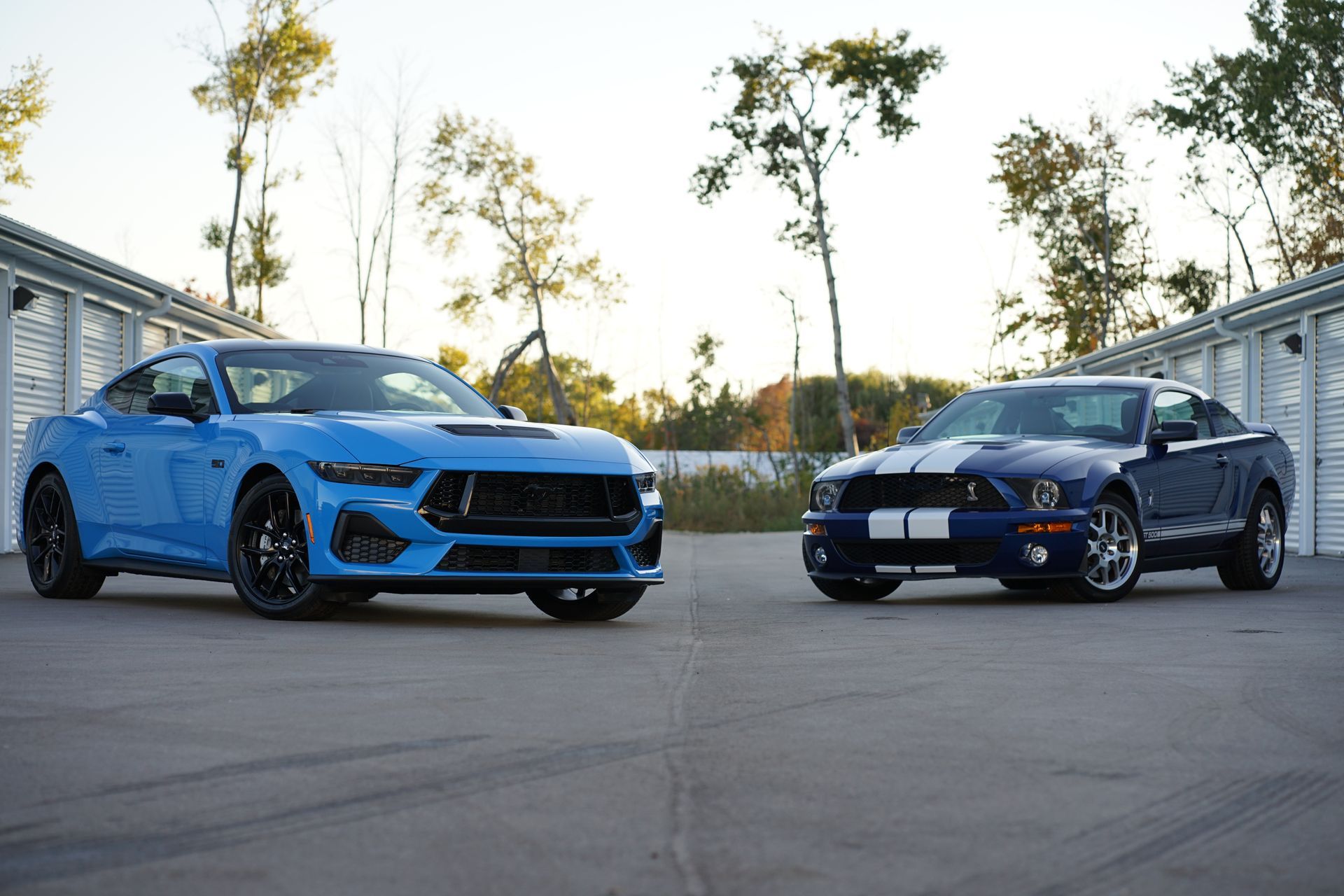 A person is cleaning a blue car with an orange towel