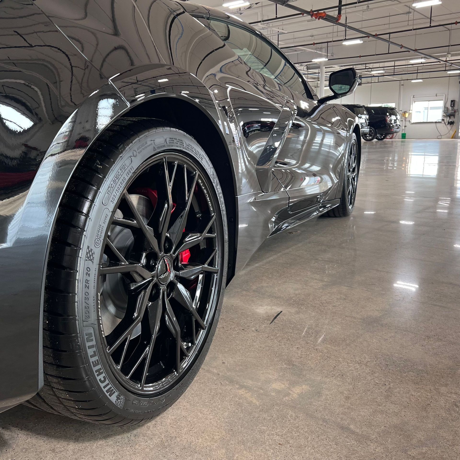 A person is wrapping a car with clear plastic