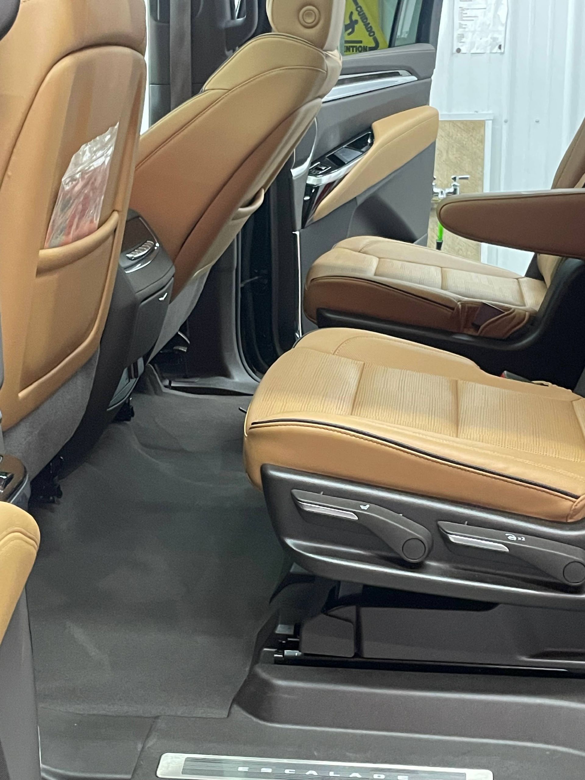 A person wearing black gloves is polishing a black car