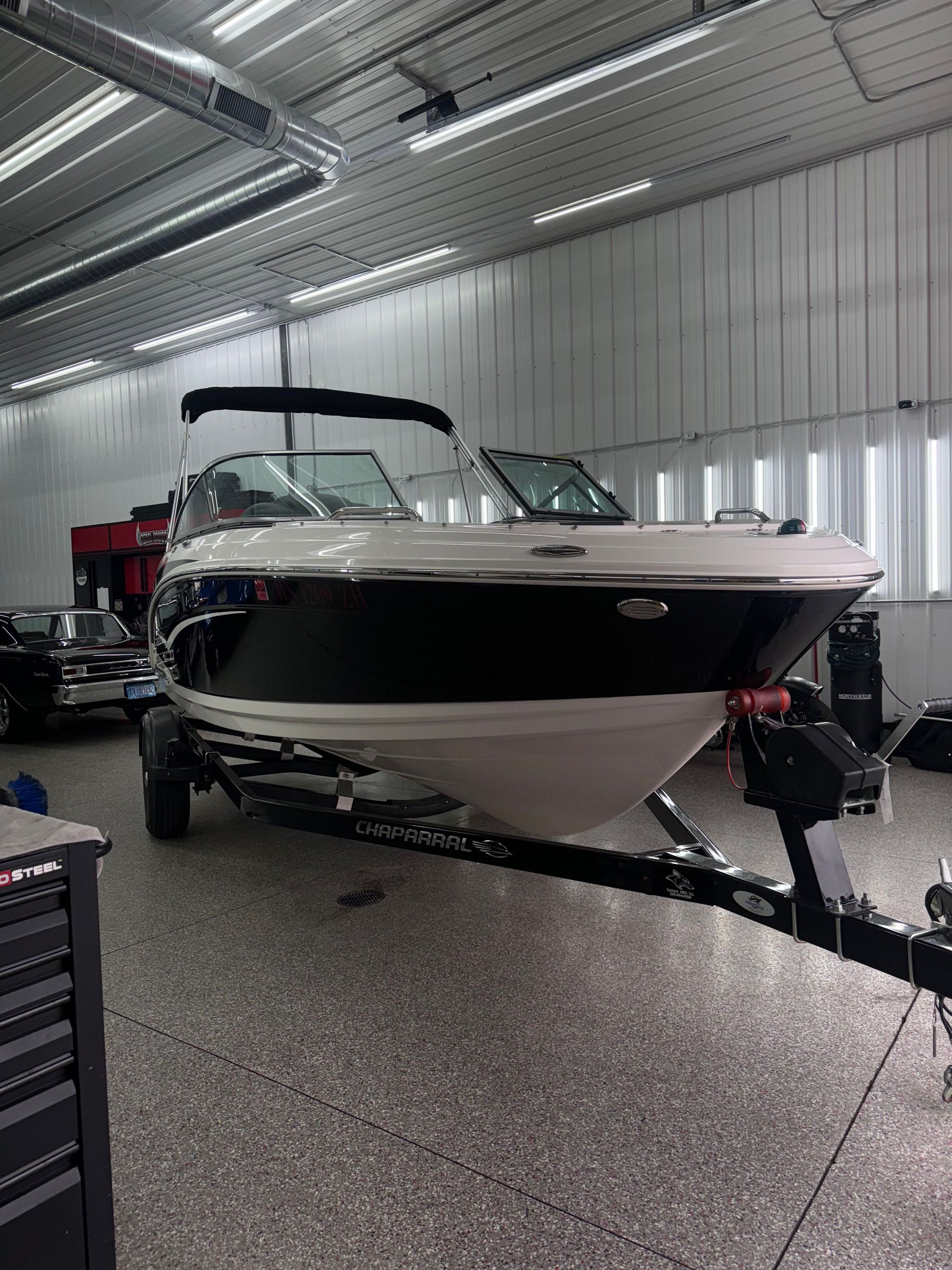 A person is cleaning a blue car with an orange towel