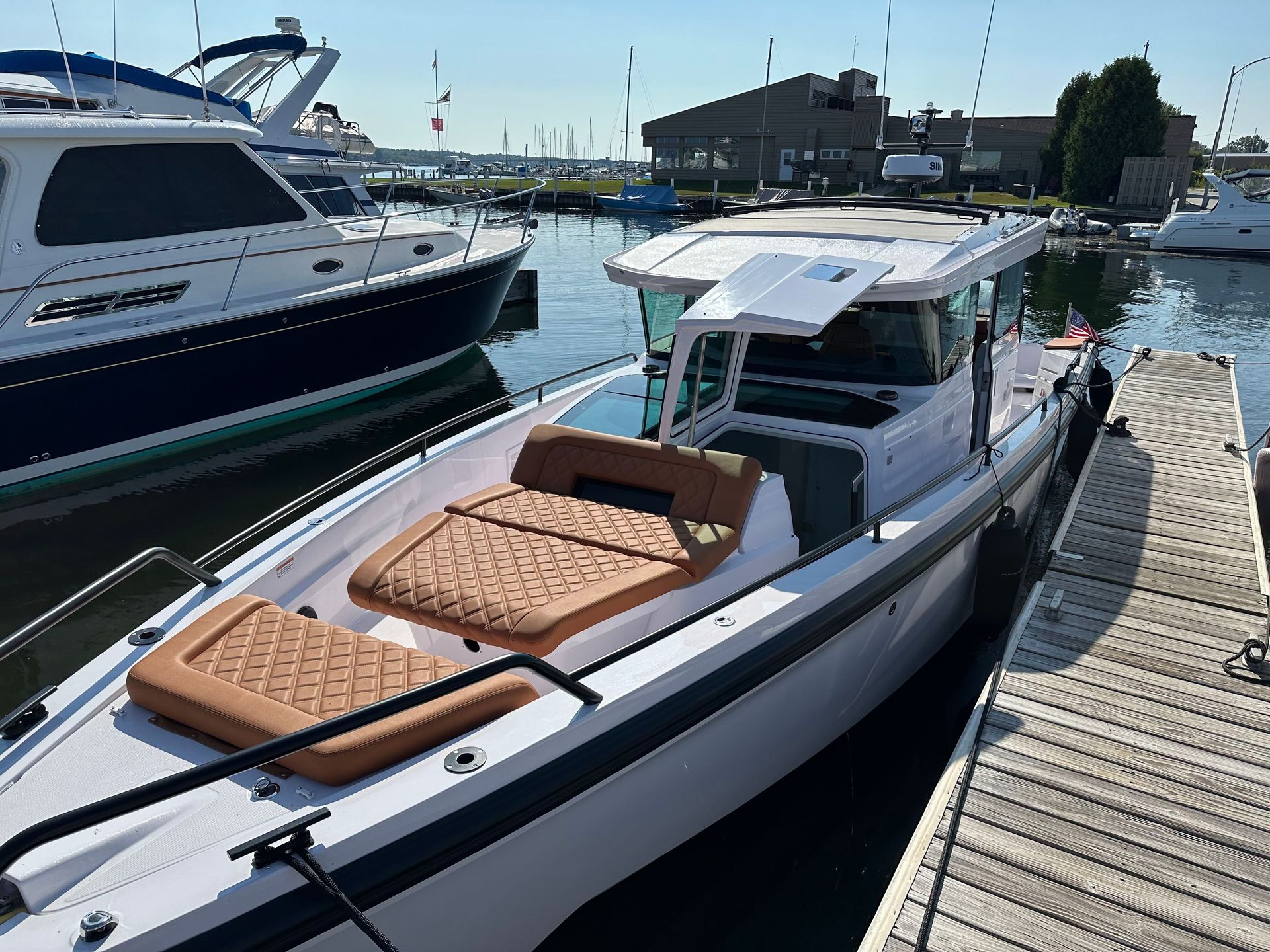 A man is cleaning the wheel of a black car with a sponge.