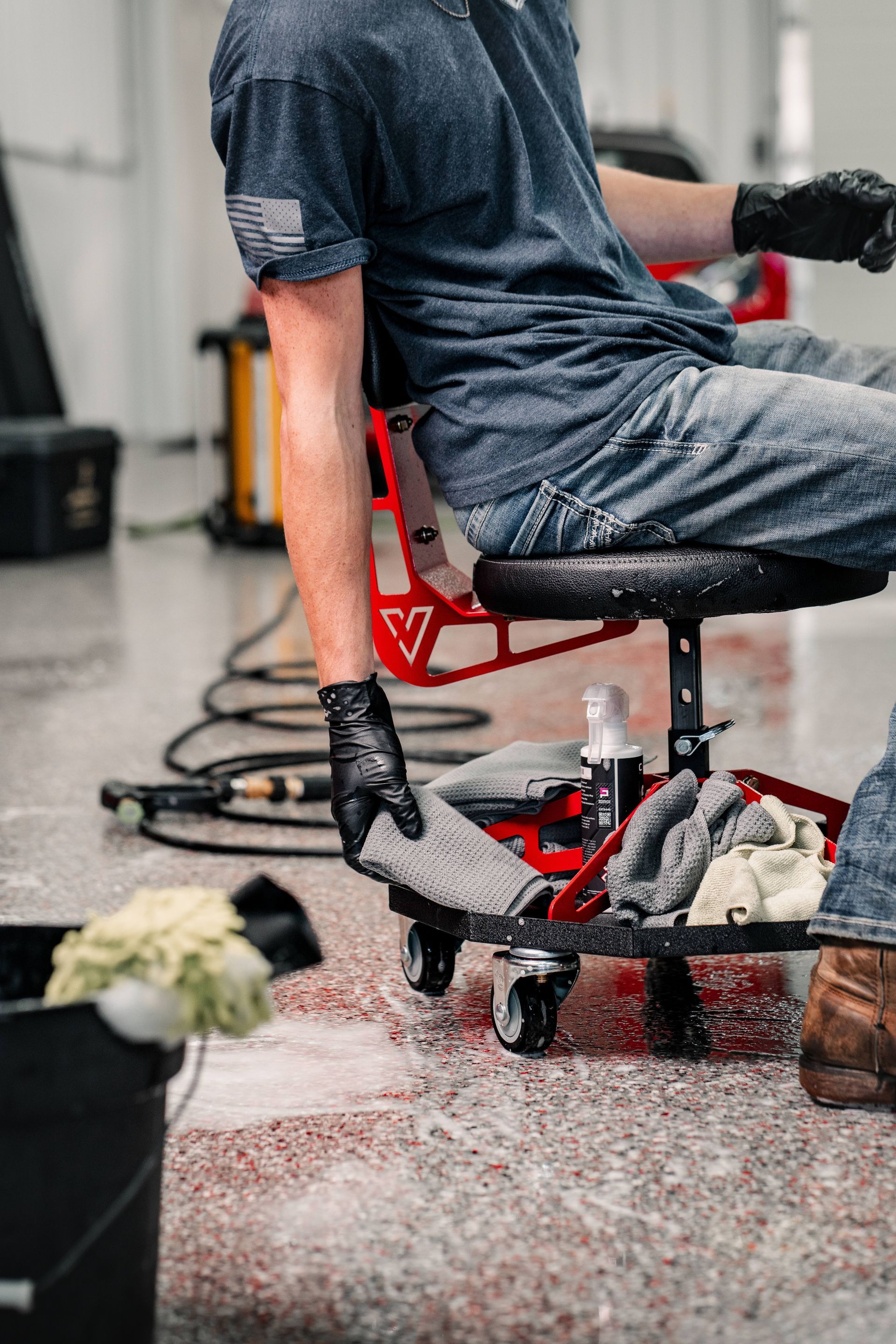 A car is covered in plastic wrap in a garage.