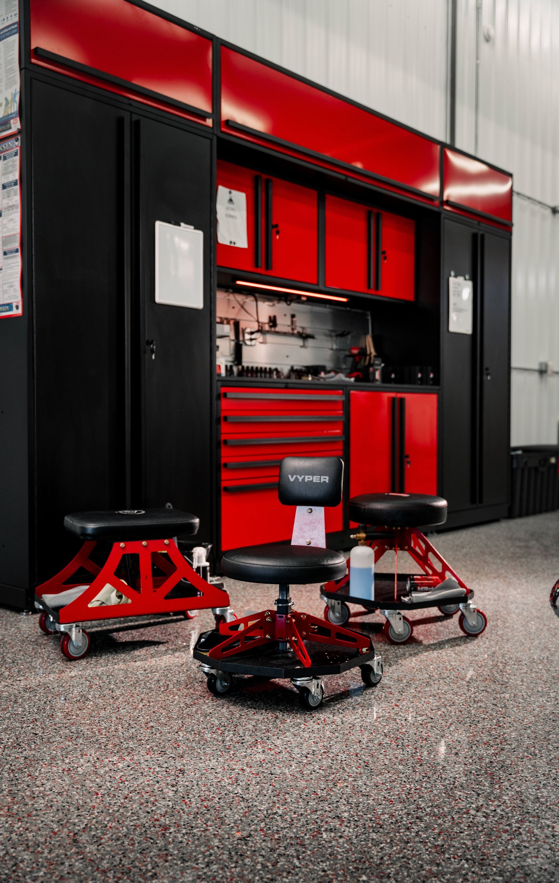 A person is using a blue squeegee to remove plastic from the hood of a car