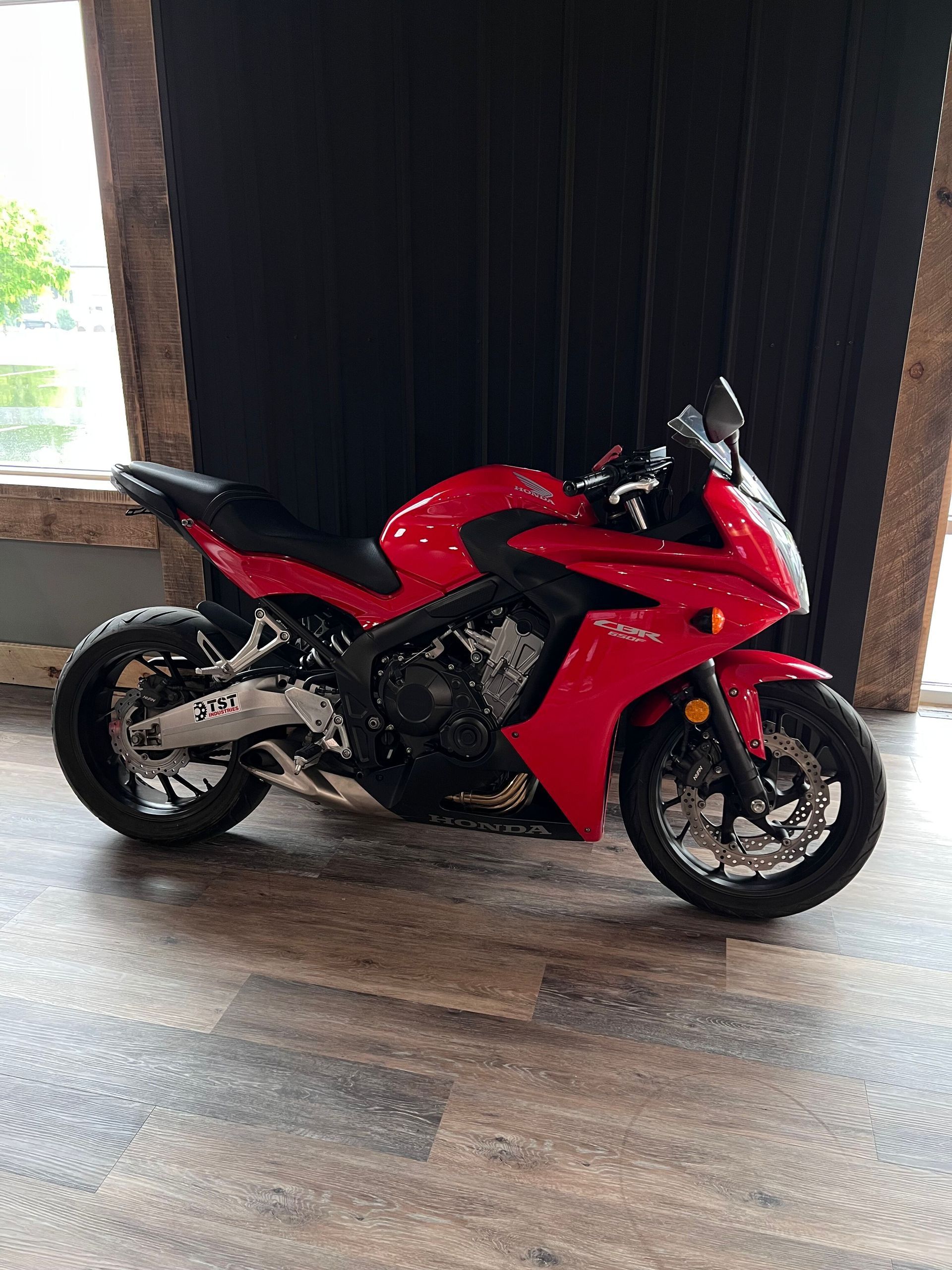 A person is cleaning a blue car with an orange towel
