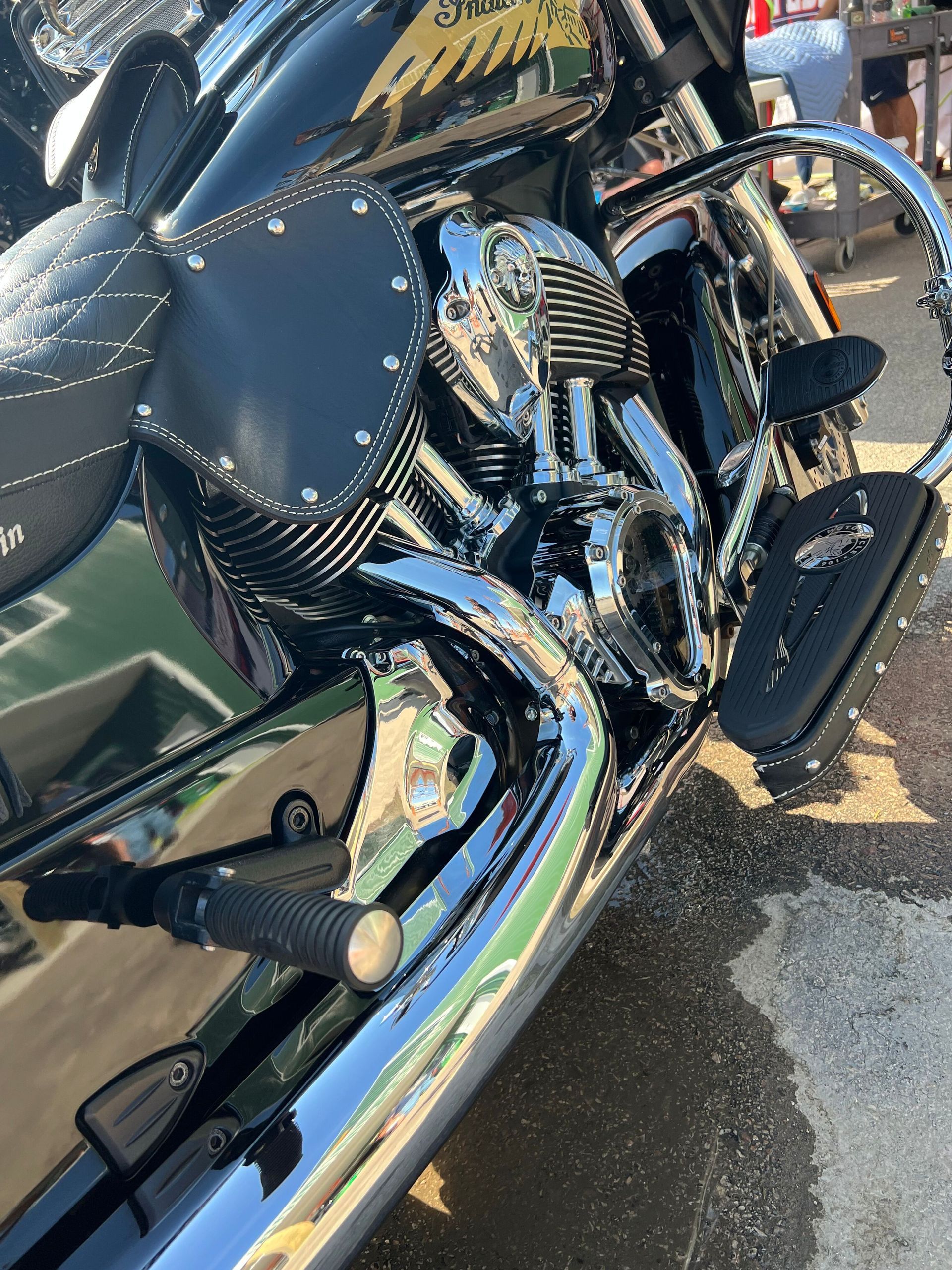 A person is cleaning a blue car with an orange towel