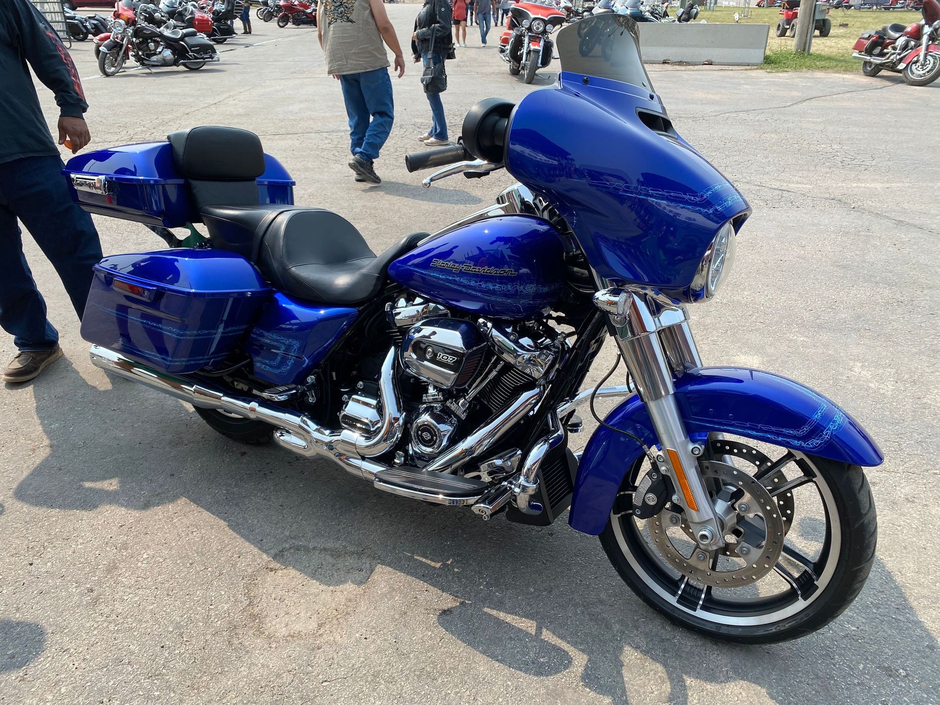 A man is cleaning the wheel of a black car with a sponge.