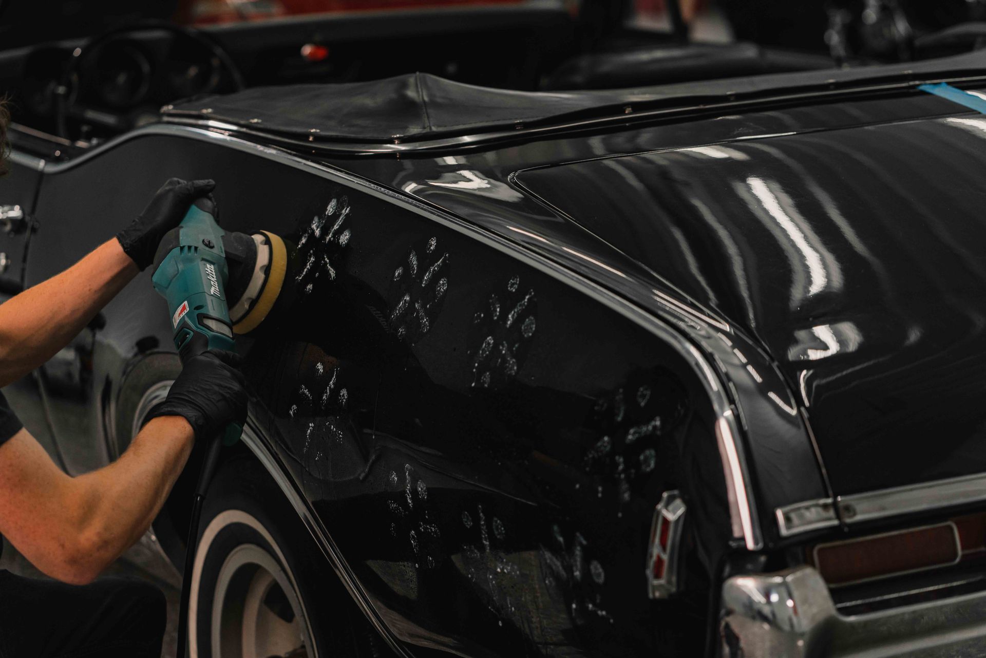 A person is applying tinted glass to a car windshield.