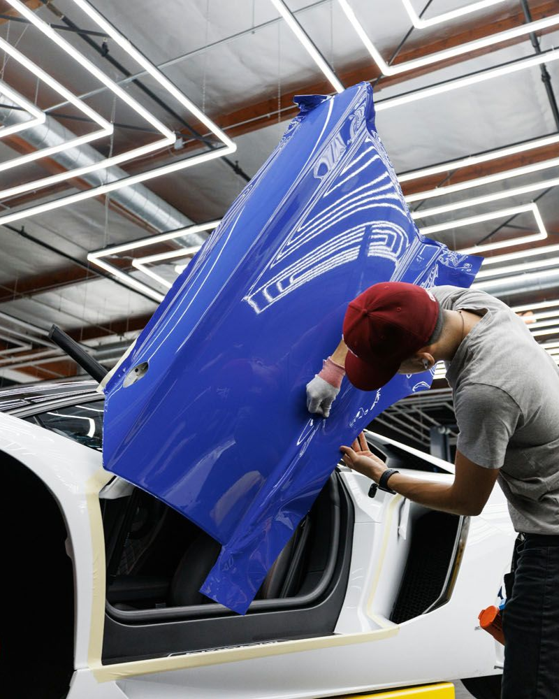 A yellow sports car is parked in a garage.