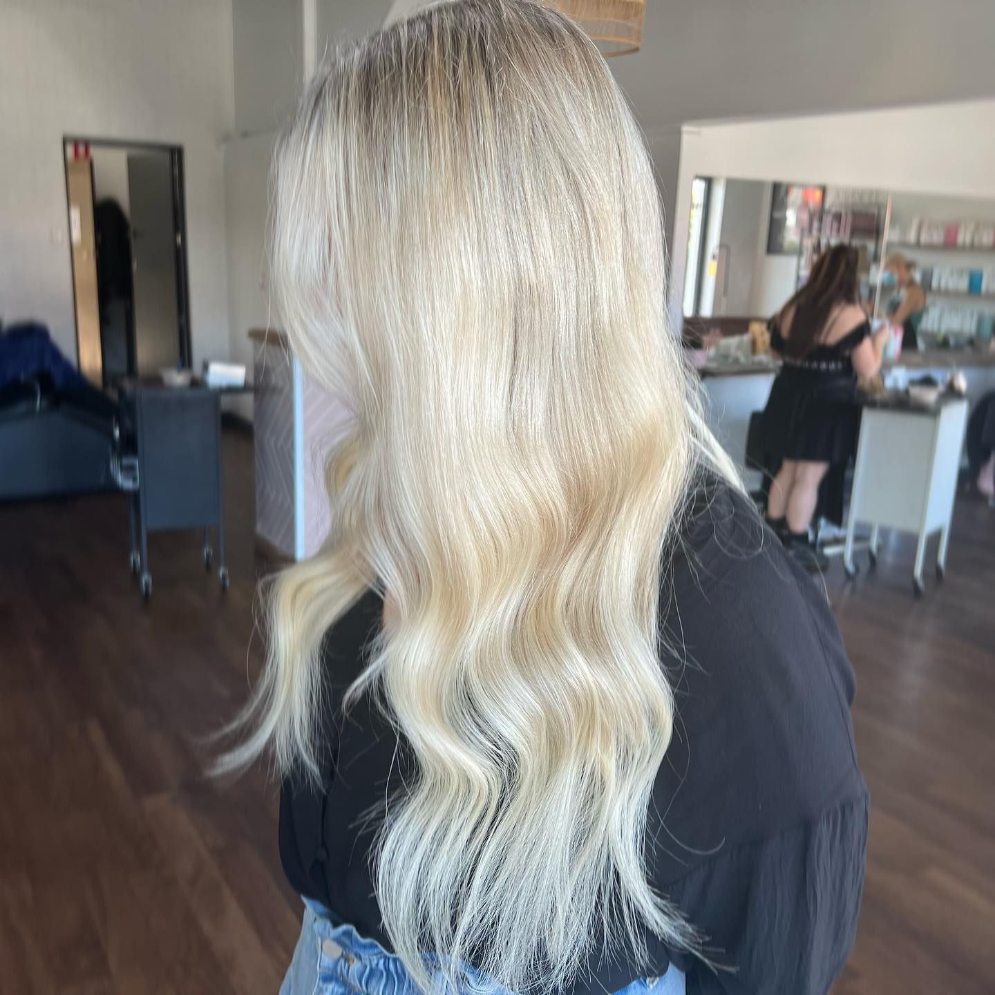 Woman with long, wavy, blonde hair at a salon.