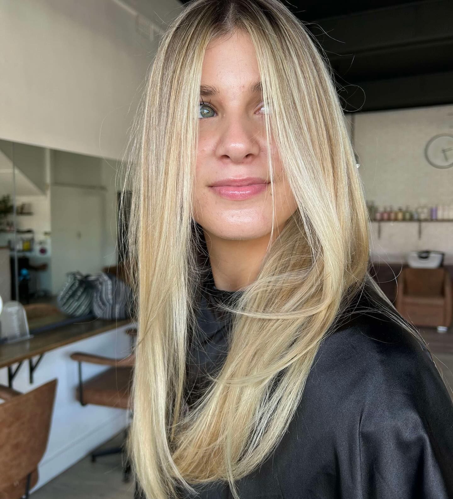 Blonde hair with streaks and layers. Woman in a hair salon.