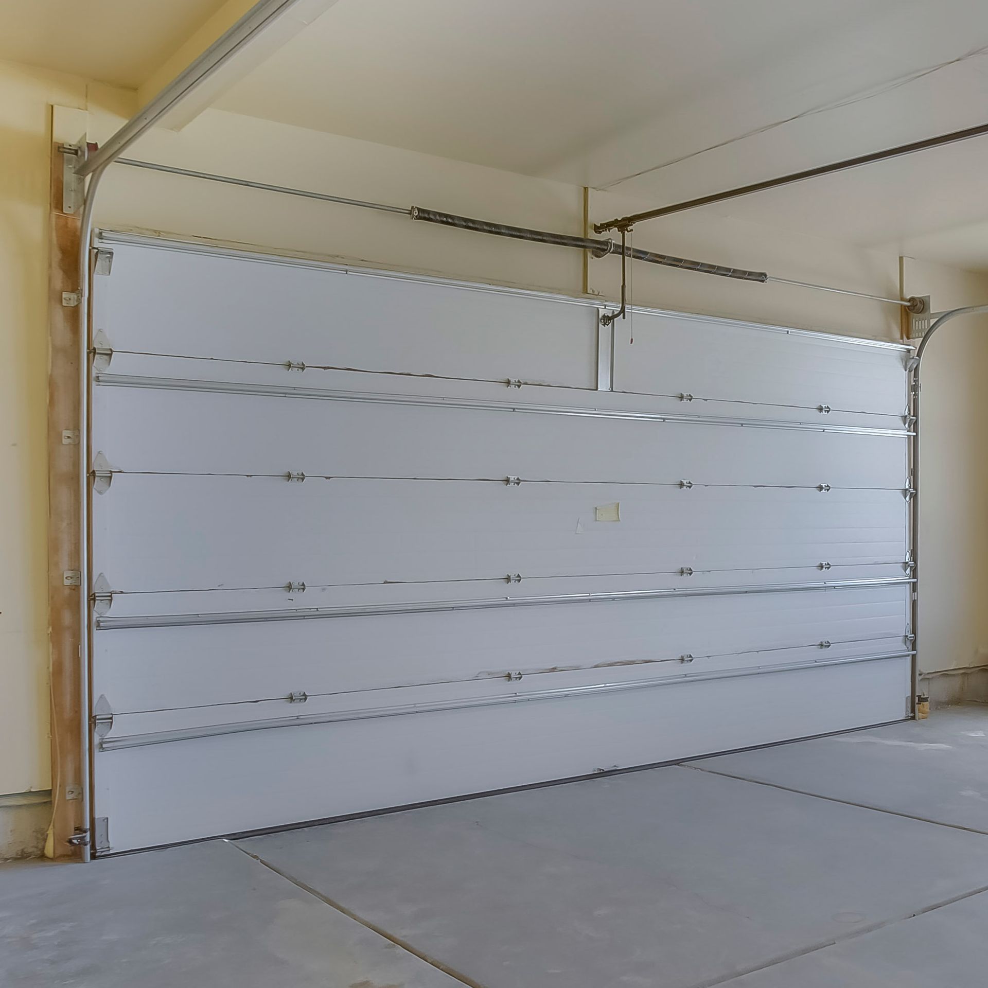 White door square frame empty garage highlighting durable and efficient garage door system.