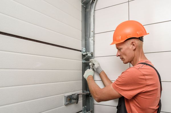 A worker is installing lift gates in the garage.