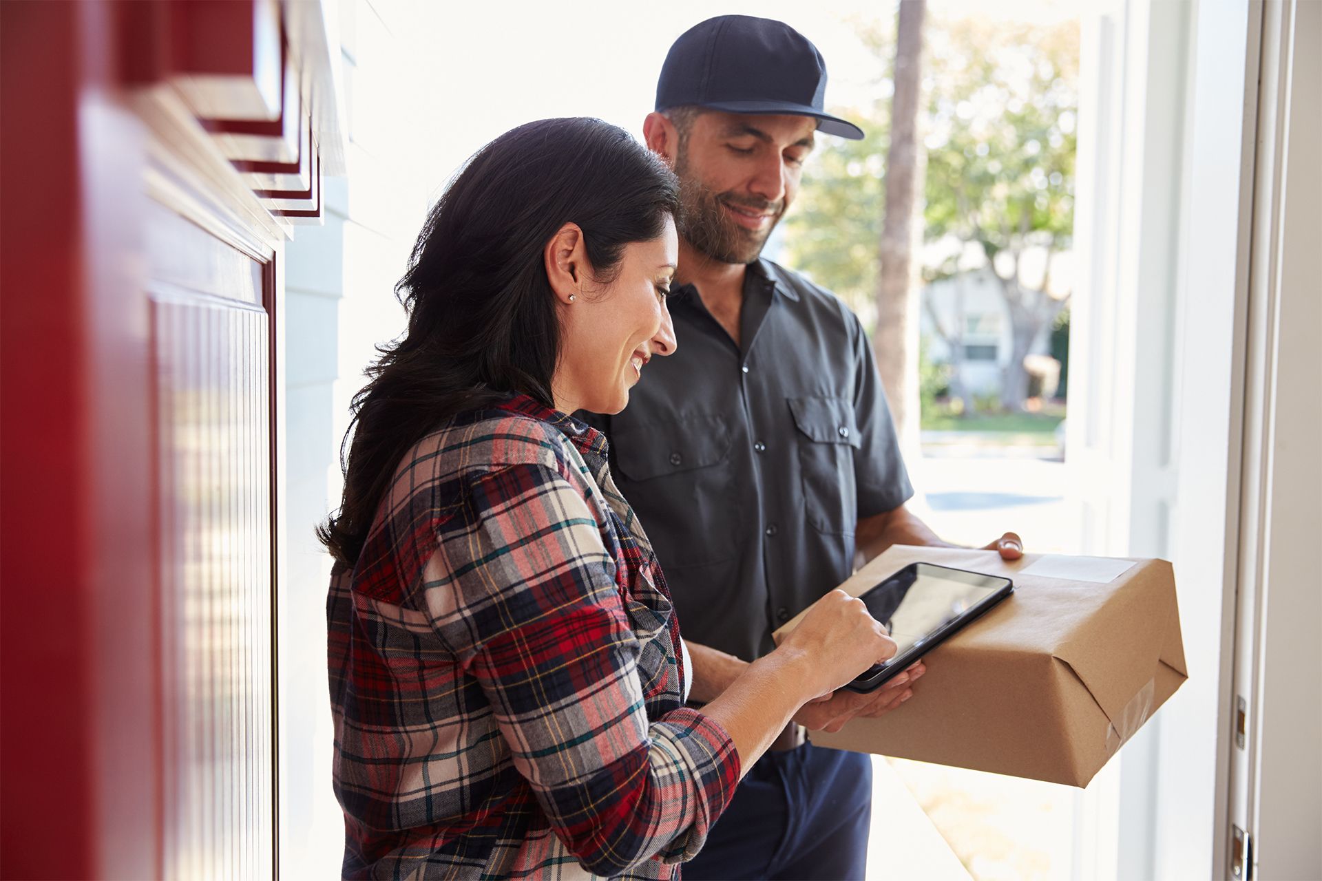 Woman Signing on Tablet for Her Package