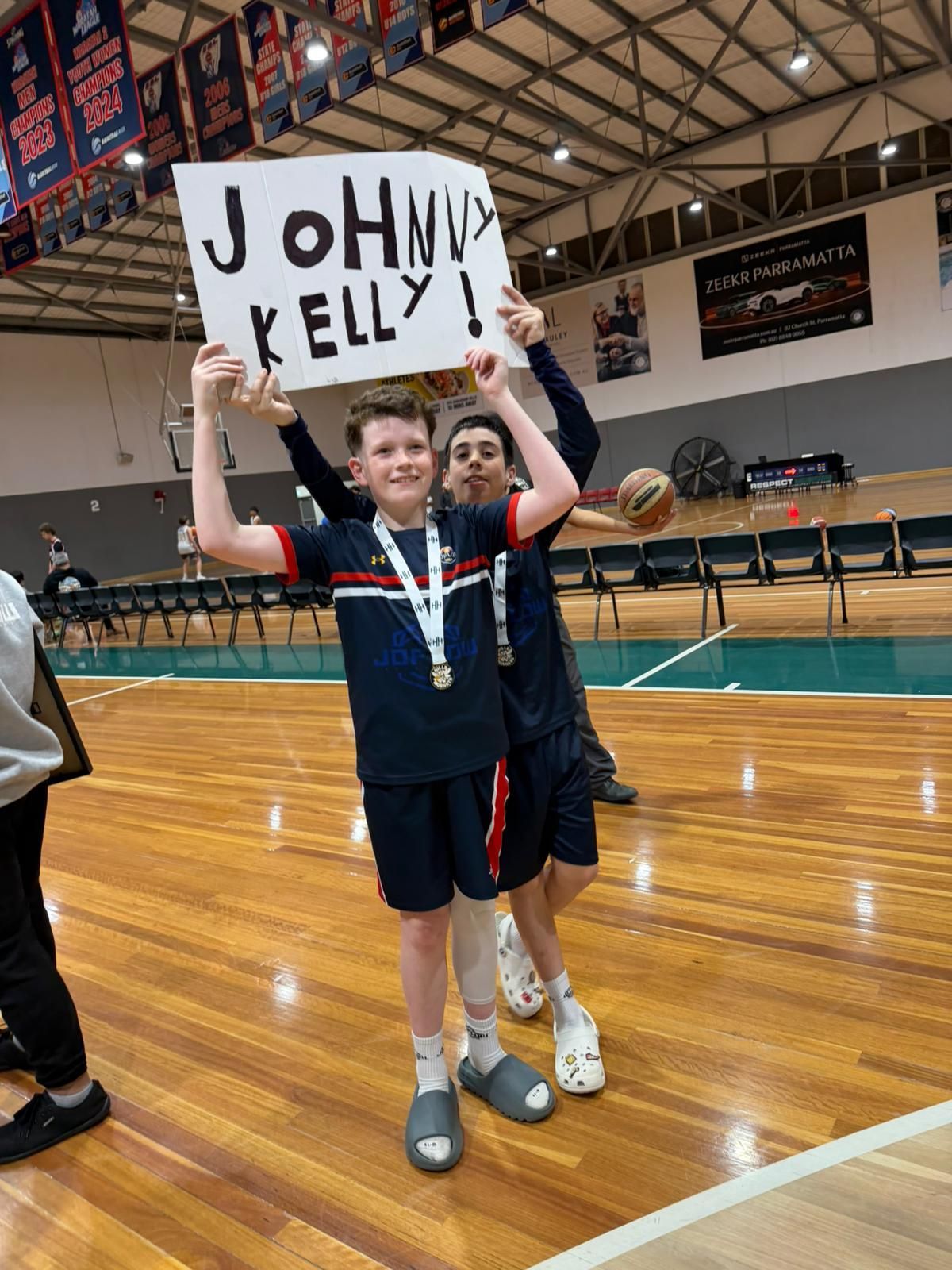 Two boys holding a sign that reads 