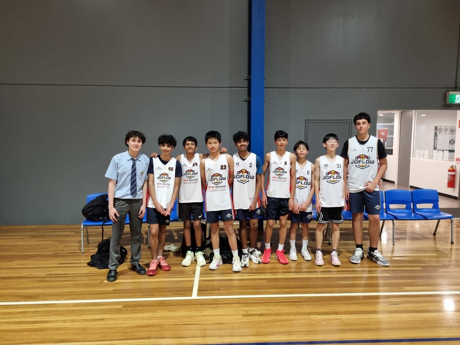 Basketball team of boys in uniforms posing on a court.