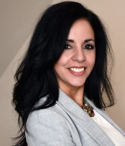 A man and a woman are sitting on a dock overlooking a lake.