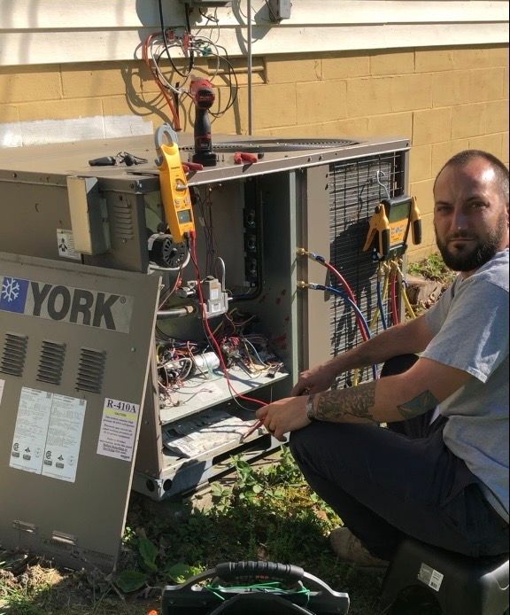 A man is working on a york air conditioner outside