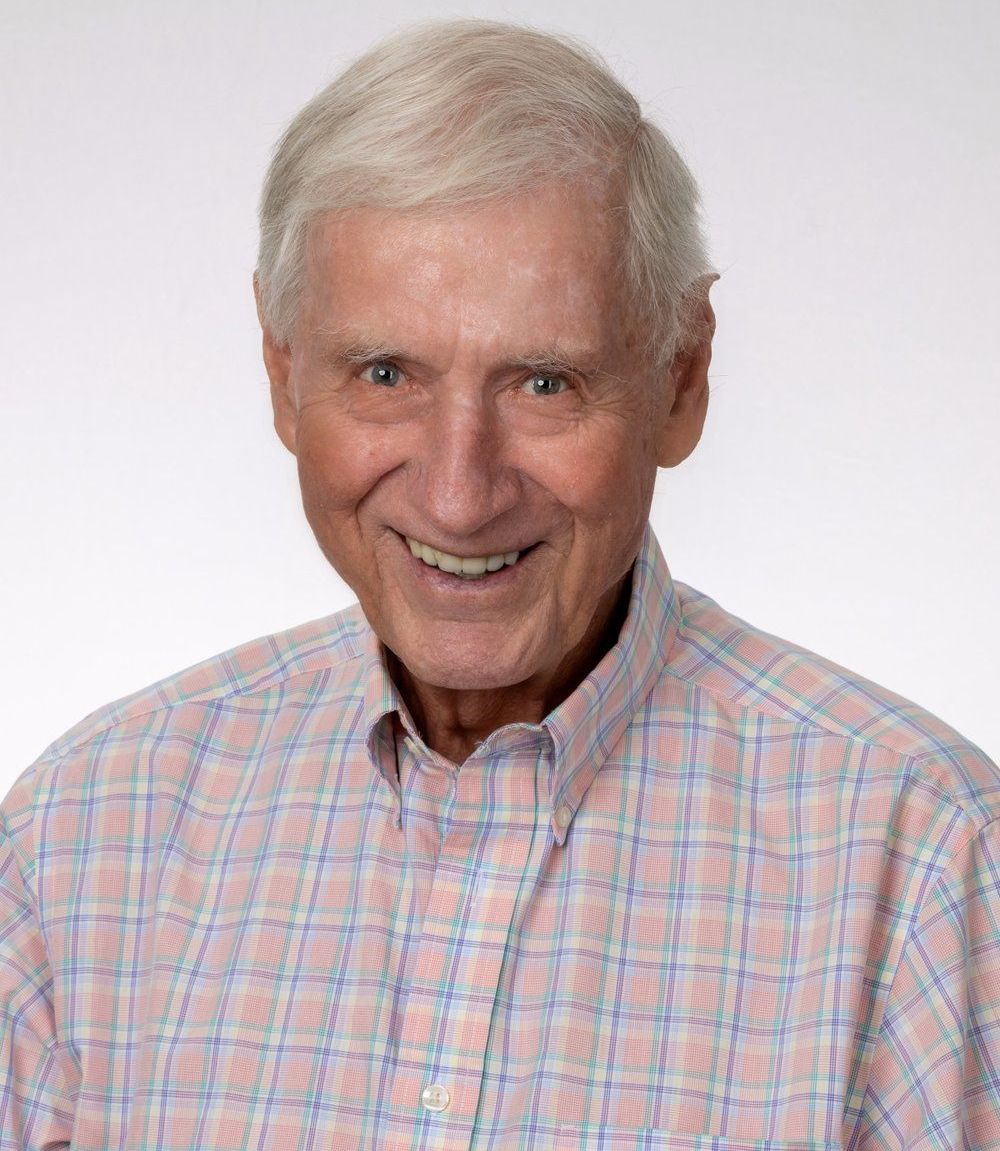 A man with a beard and a blue shirt is smiling for the camera.