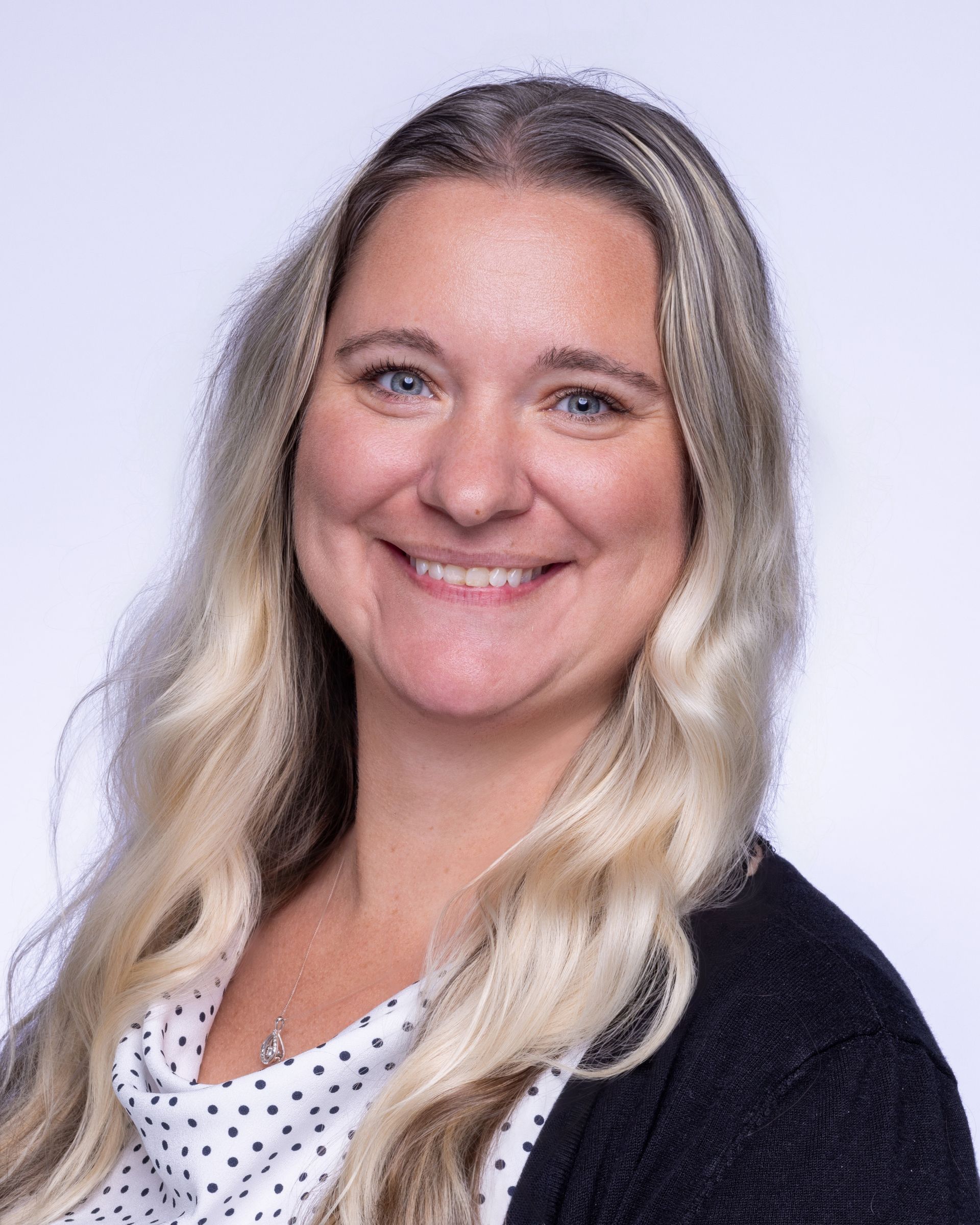 A man with a beard and a blue shirt is smiling for the camera.