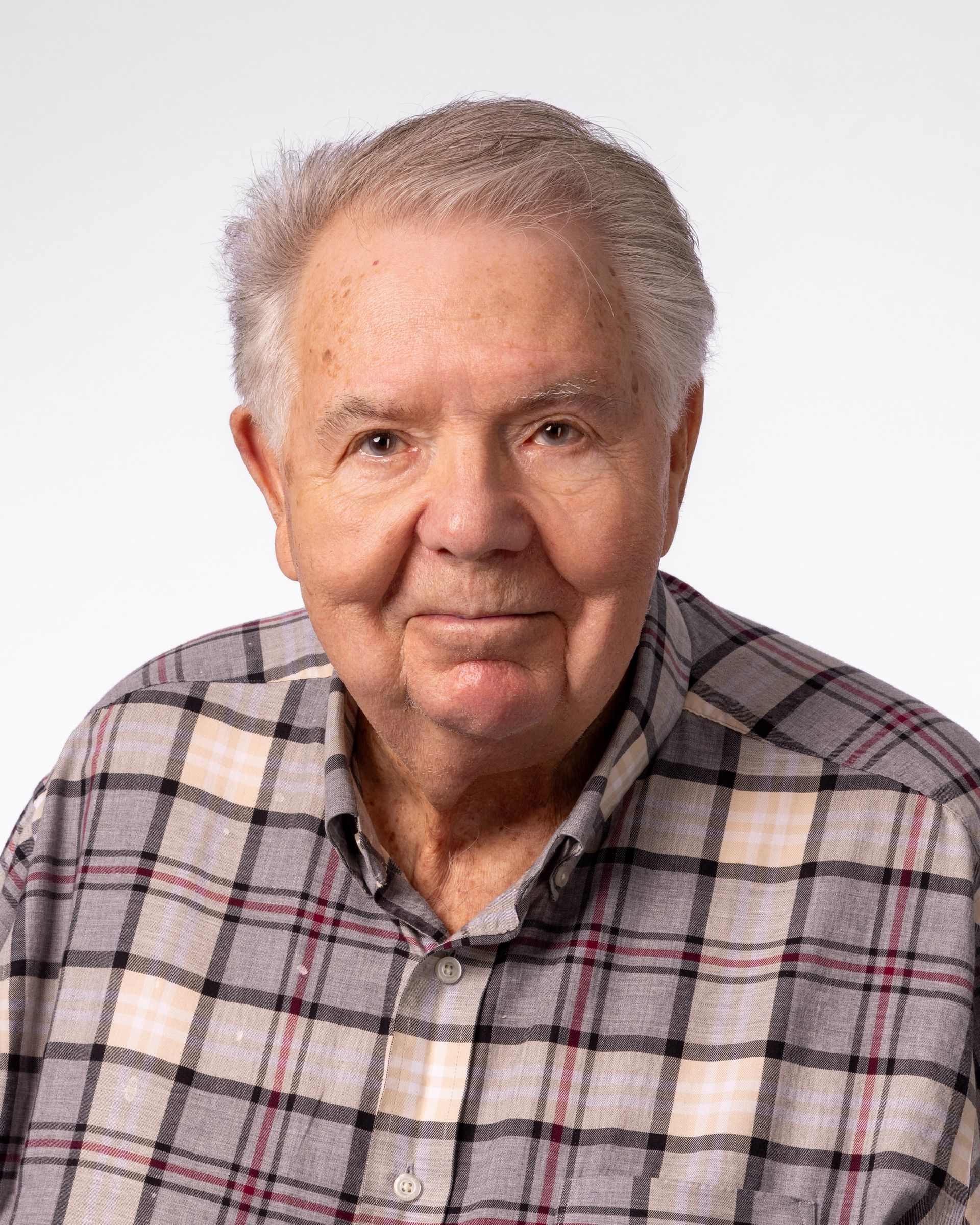A bald man with a beard wearing a suit and white shirt