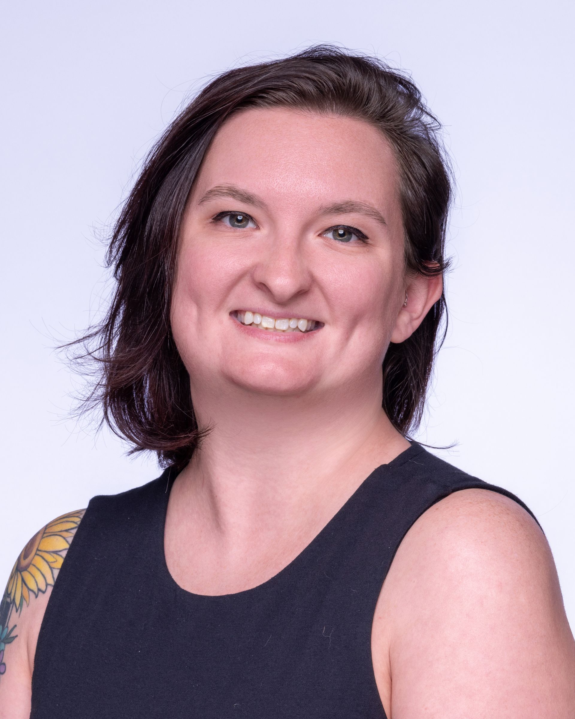 A man with a beard and a blue shirt is smiling for the camera.