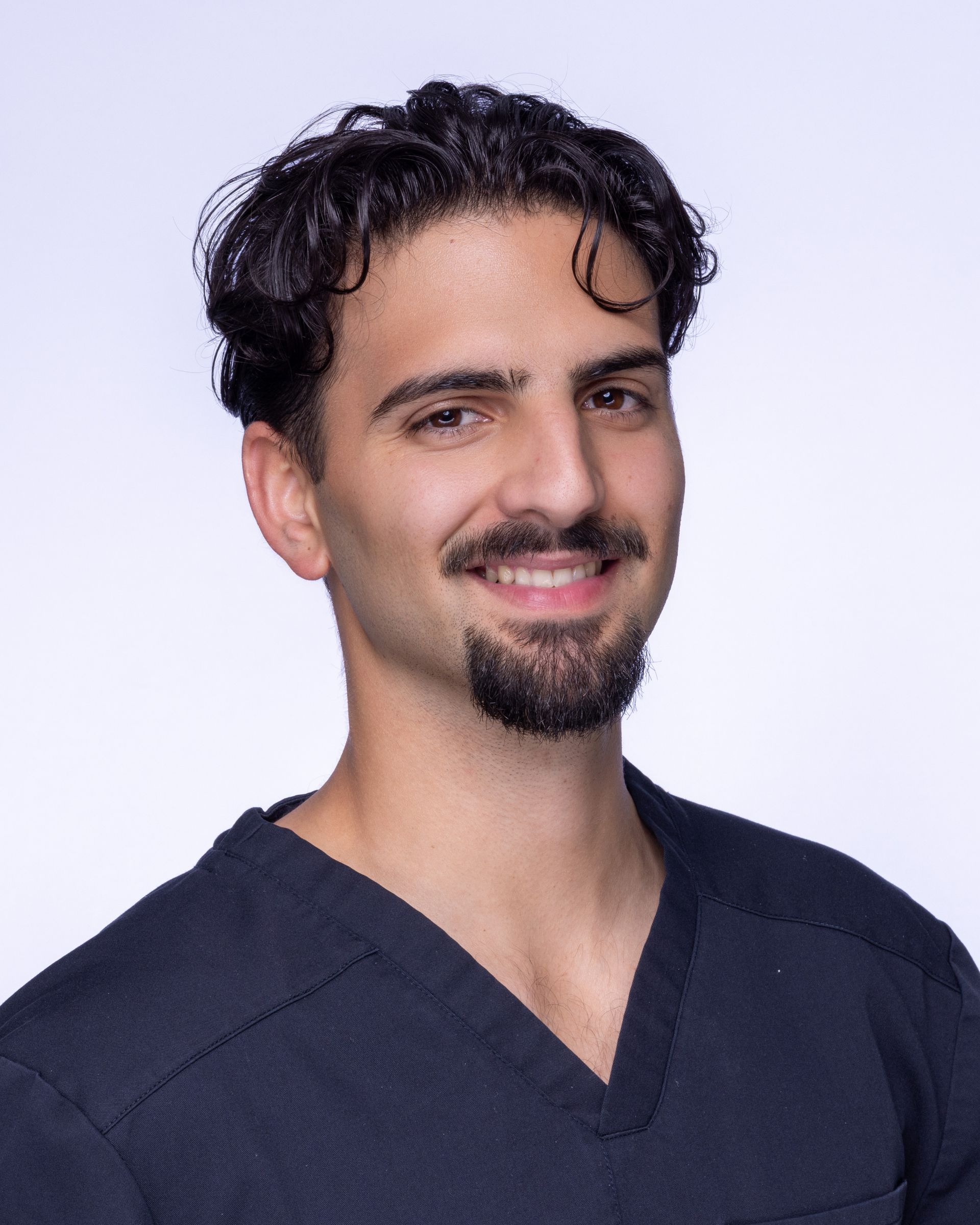 A bald man with a beard wearing a suit and white shirt