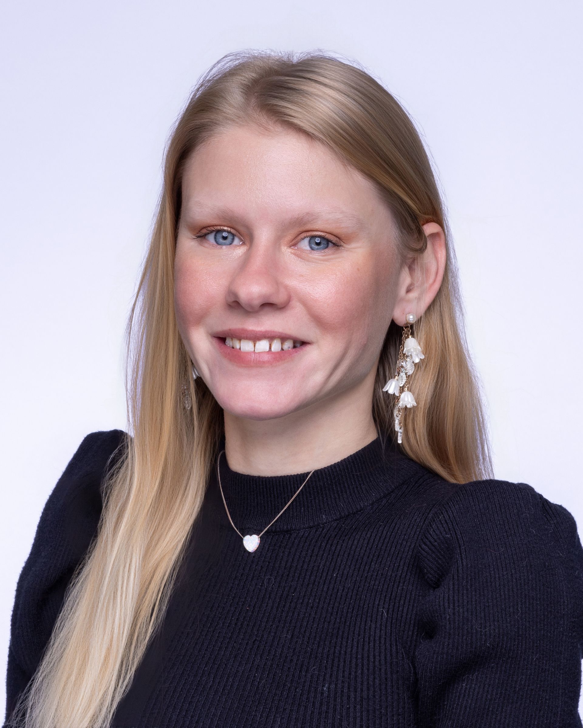 A man wearing glasses and a blue shirt is smiling for the camera.