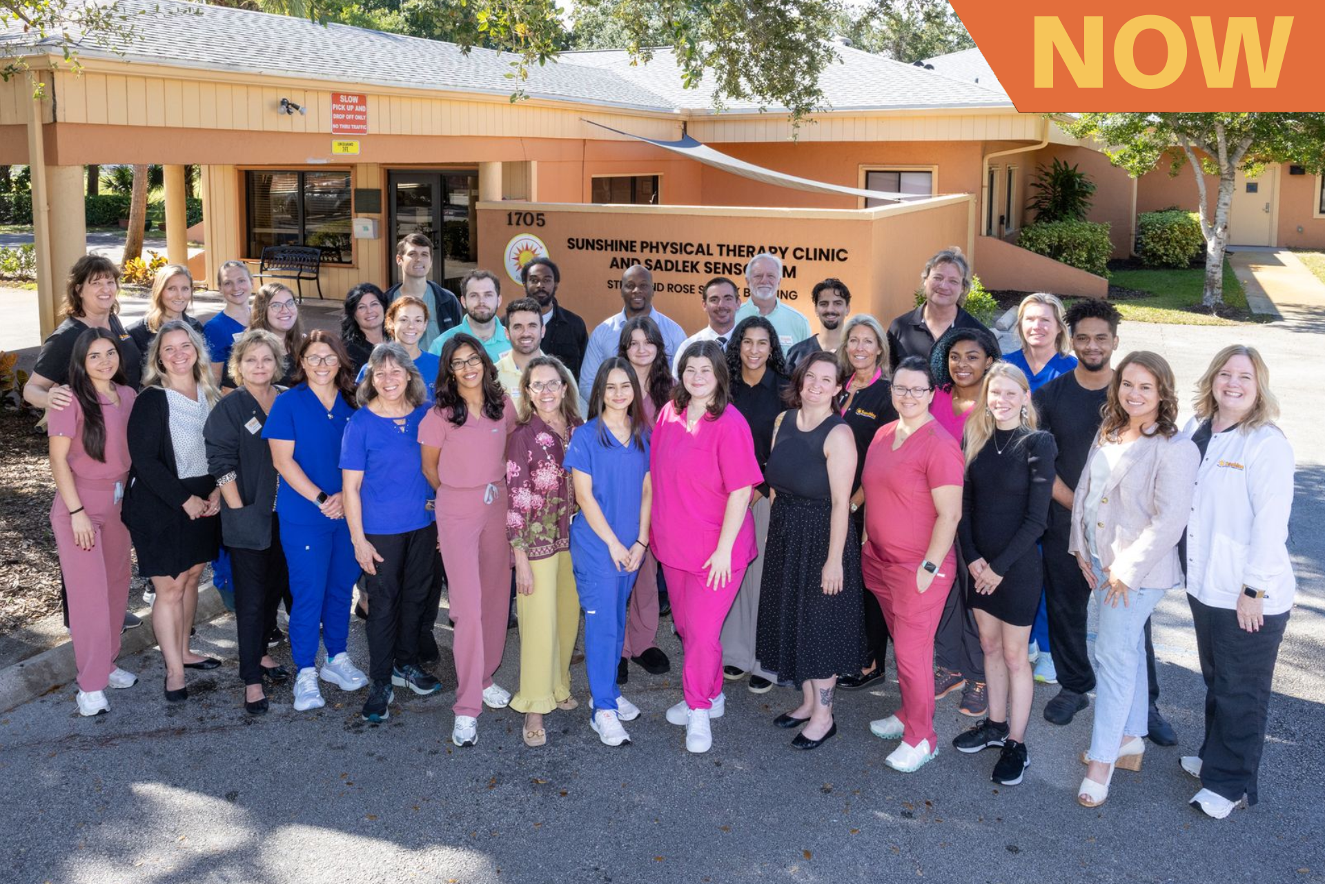 A large group of people are posing for a picture in front of a building.