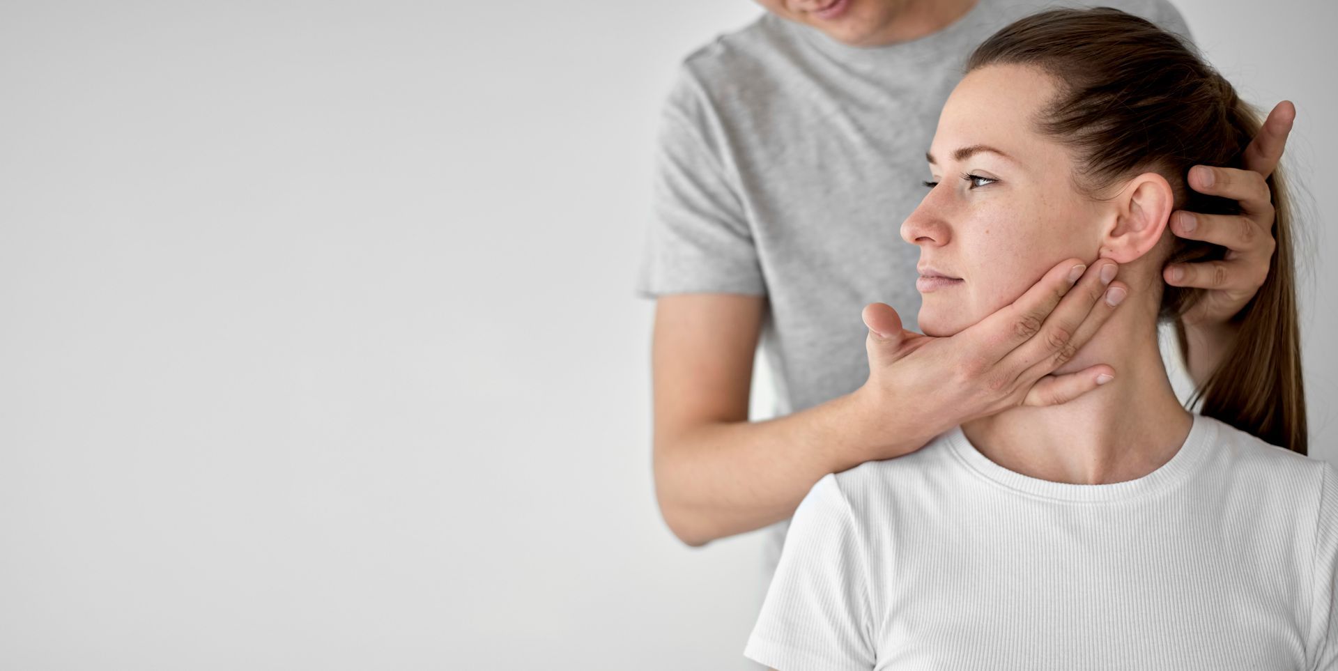 A woman is getting a neck massage from a man.
