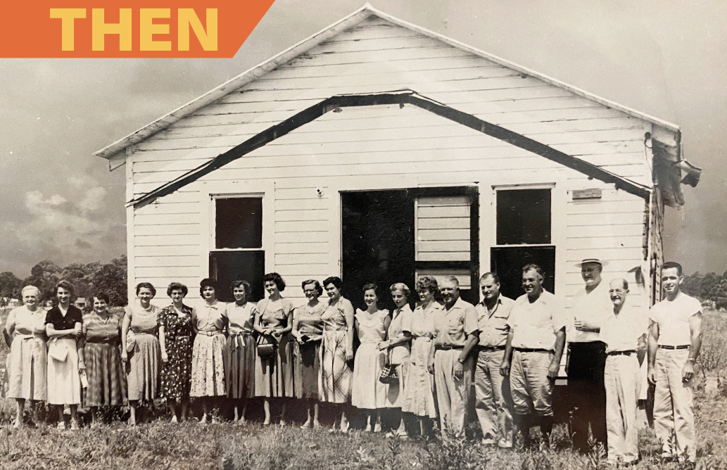 A group of people standing in front of a white building with the word then above them