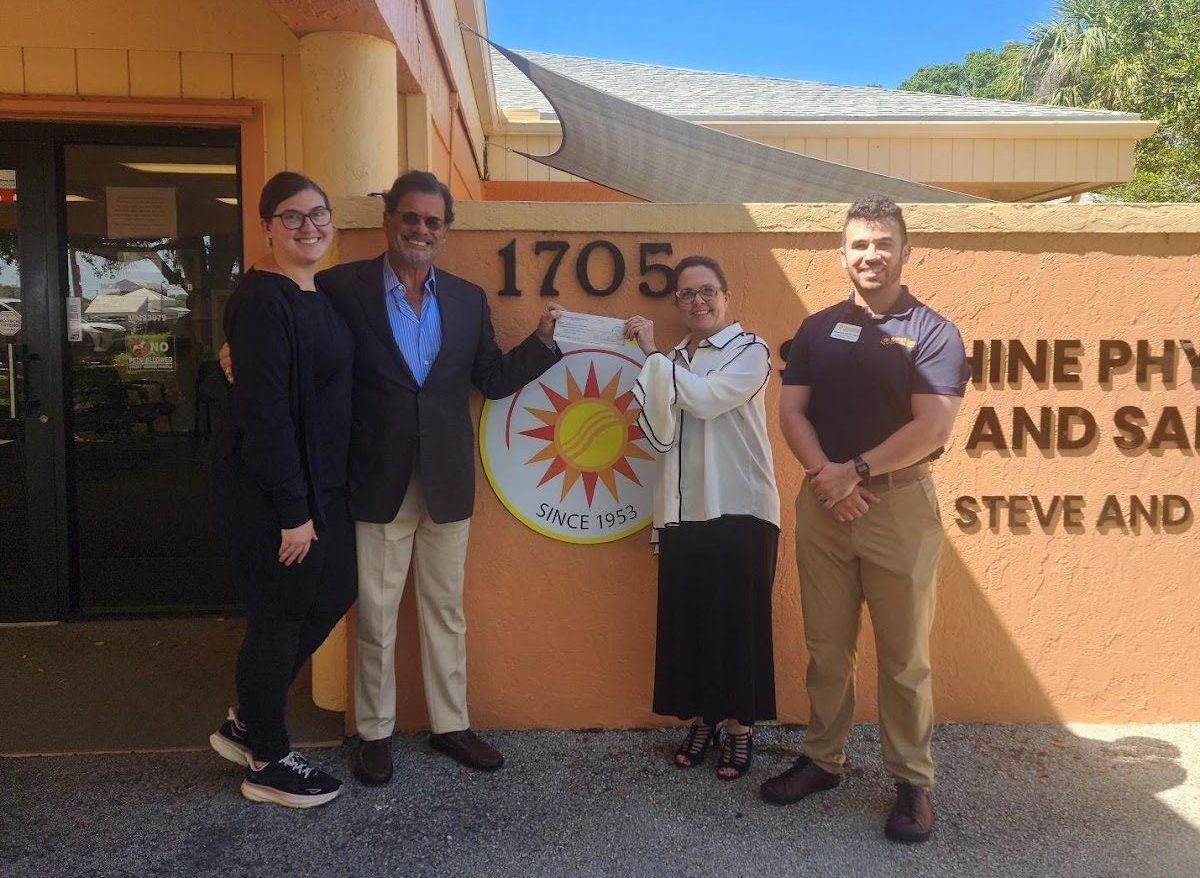 A group of people standing in front of a building with the number 1705 on it