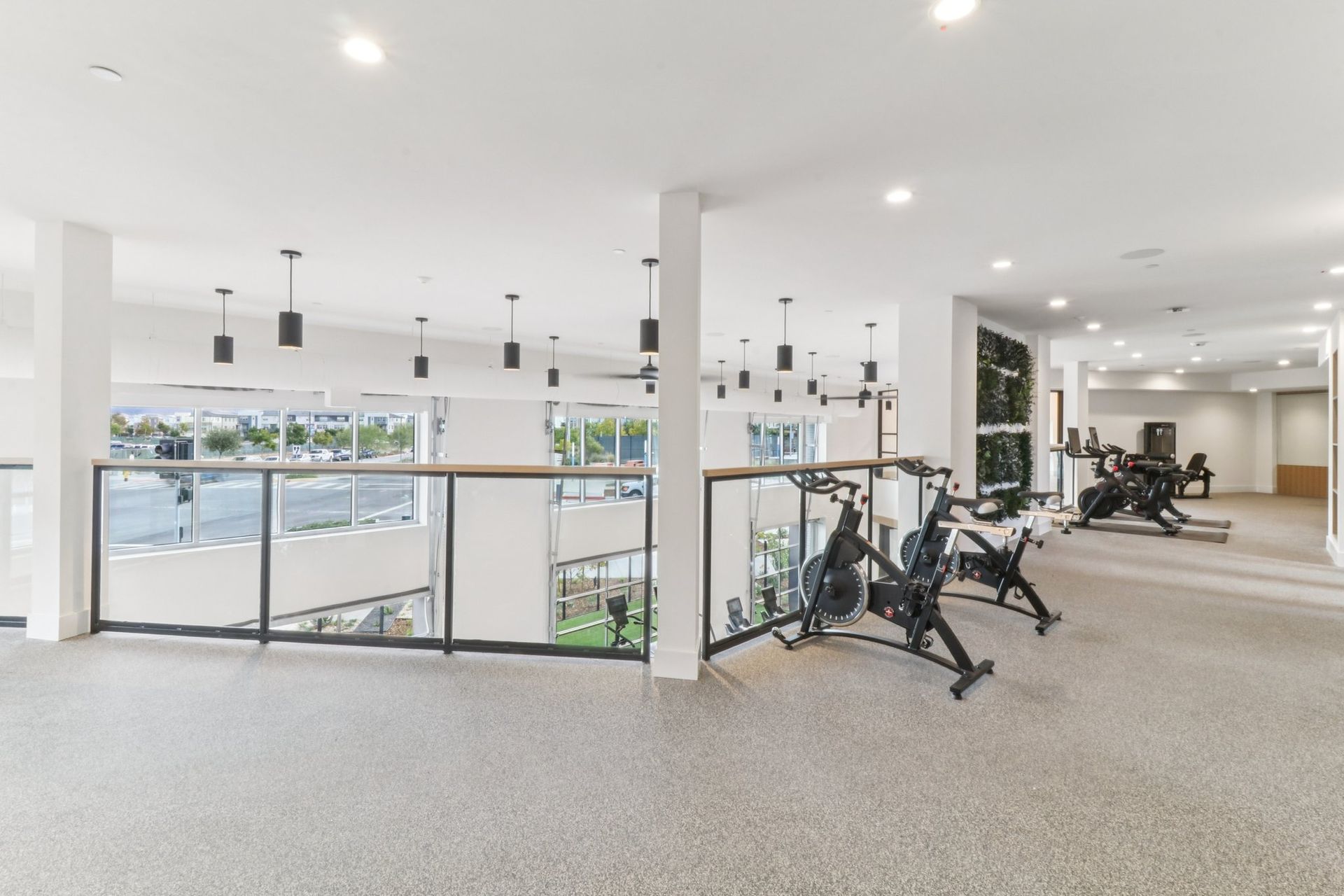 Modern fitness center with exercise equipment, overlooking a view from a high level.
