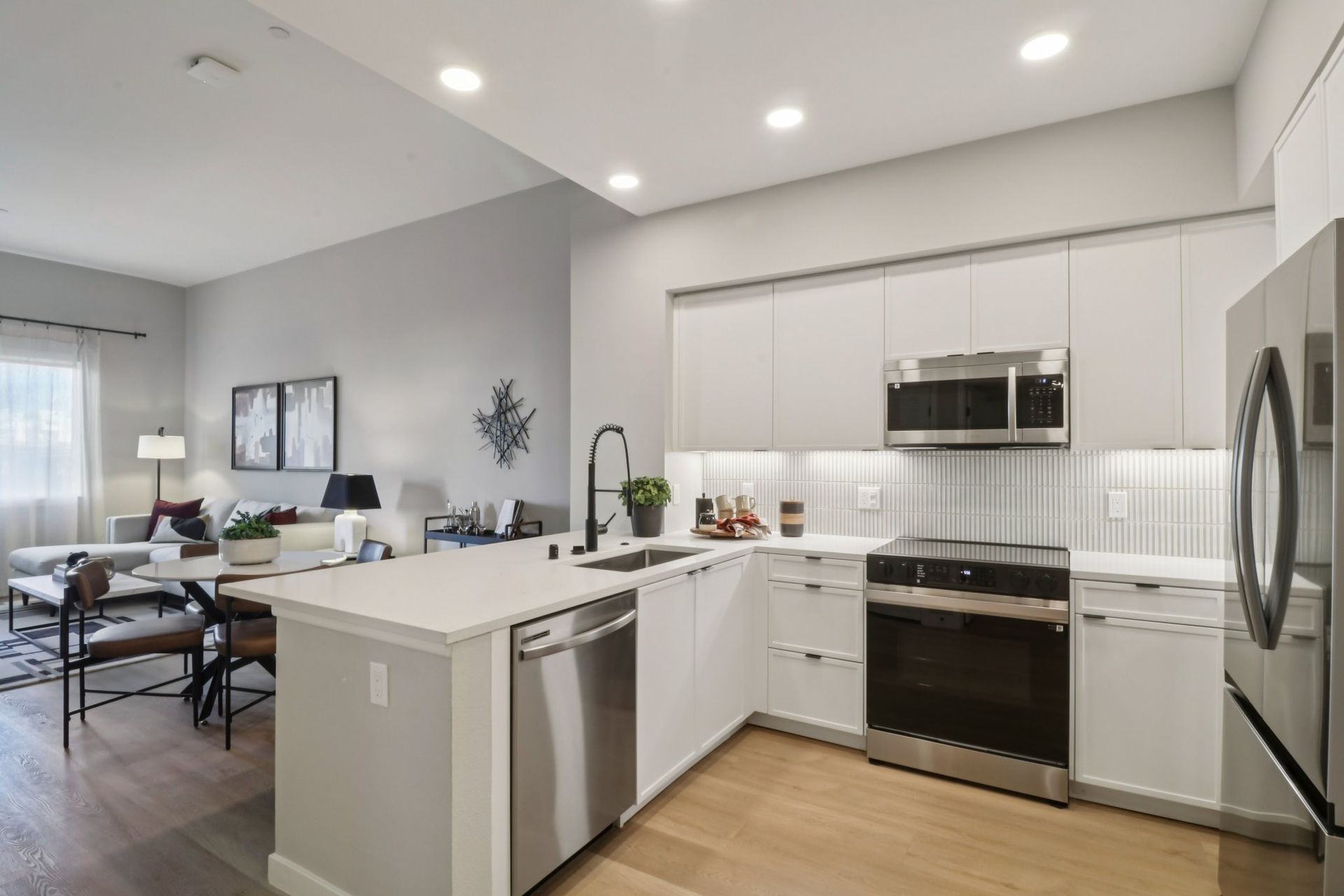 Modern kitchen with white cabinets, stainless steel appliances, and an island.