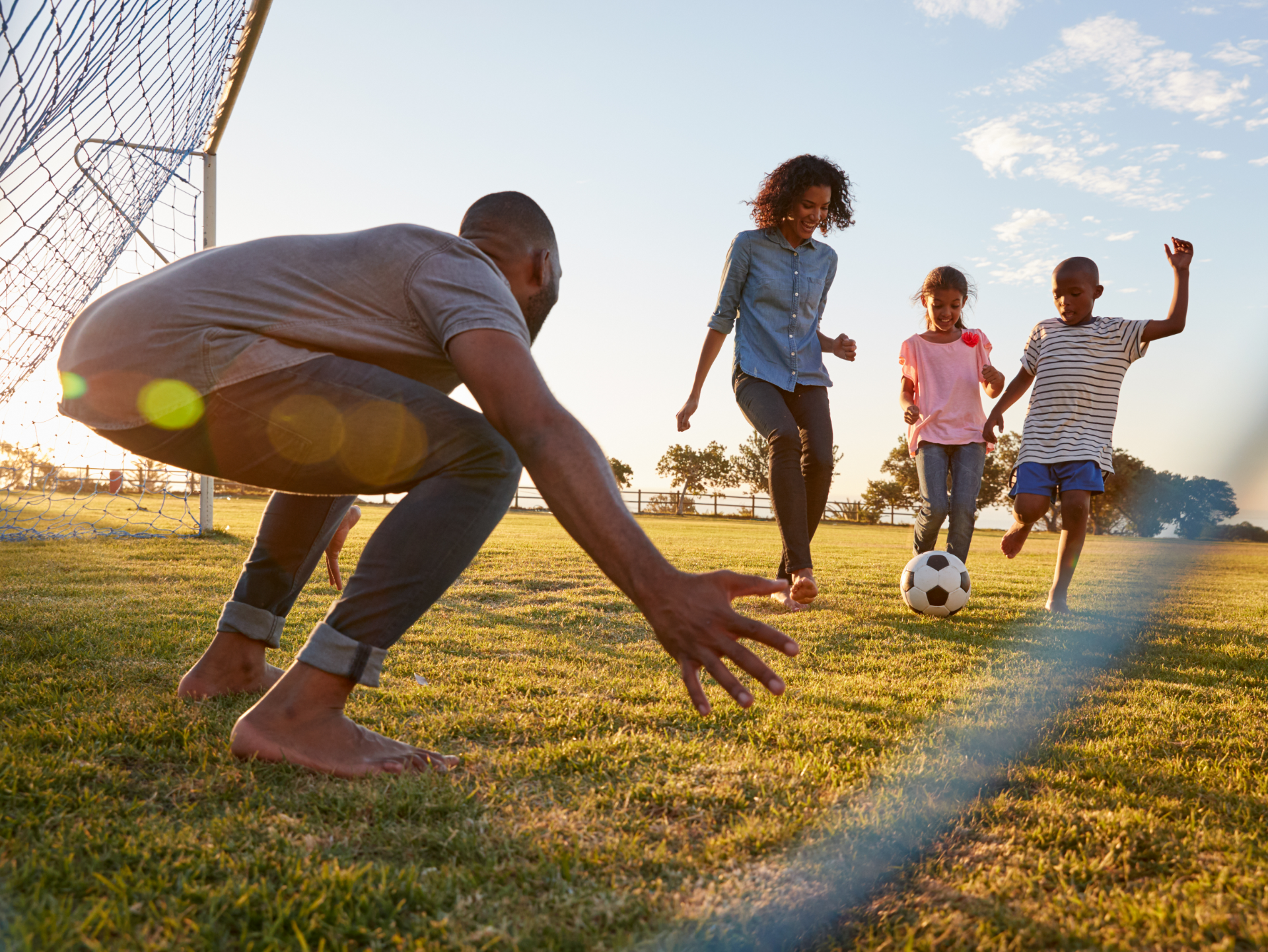 A family is playing soccer together in a field