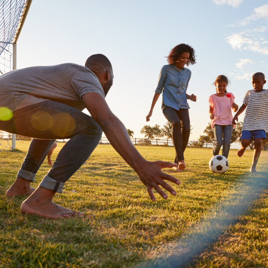 A group of people are playing soccer on a field.