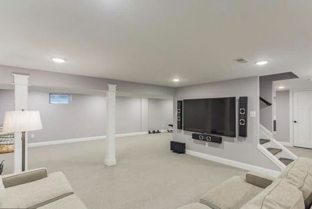 An empty living room with a fireplace and windows