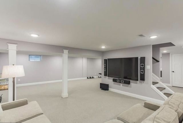An empty living room with a fireplace and windows
