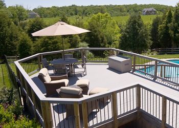 An aerial view of a large deck with a table and chairs and an umbrella.