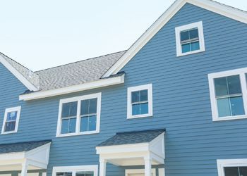 A blue house with white trim and a gray roof