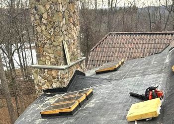 There is a chimney on the roof of a house.