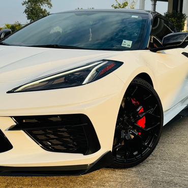 White sports car with black accents and red brake calipers.