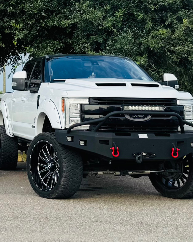 White lifted Ford pickup truck with black accents and custom bumper.