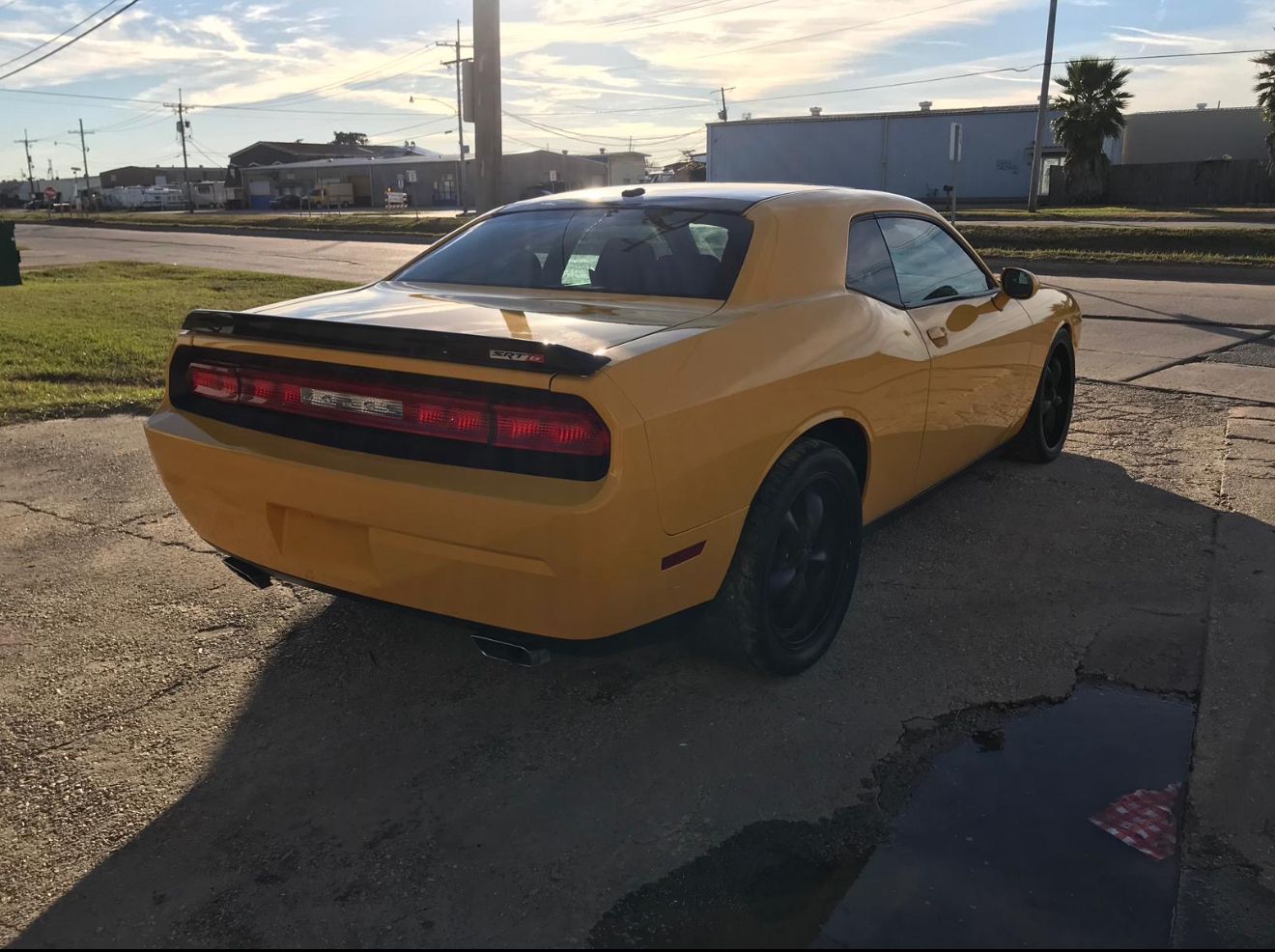 Yellow Dodge Challenger parked outdoors on a sunny day.