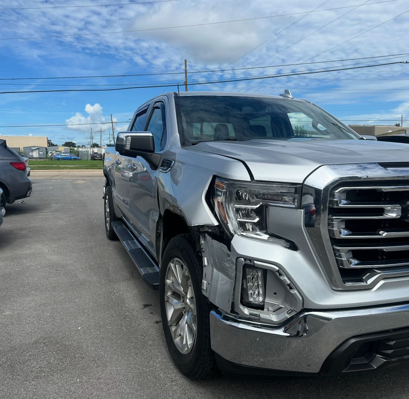 Silver GMC Sierra pickup truck parked on asphalt.