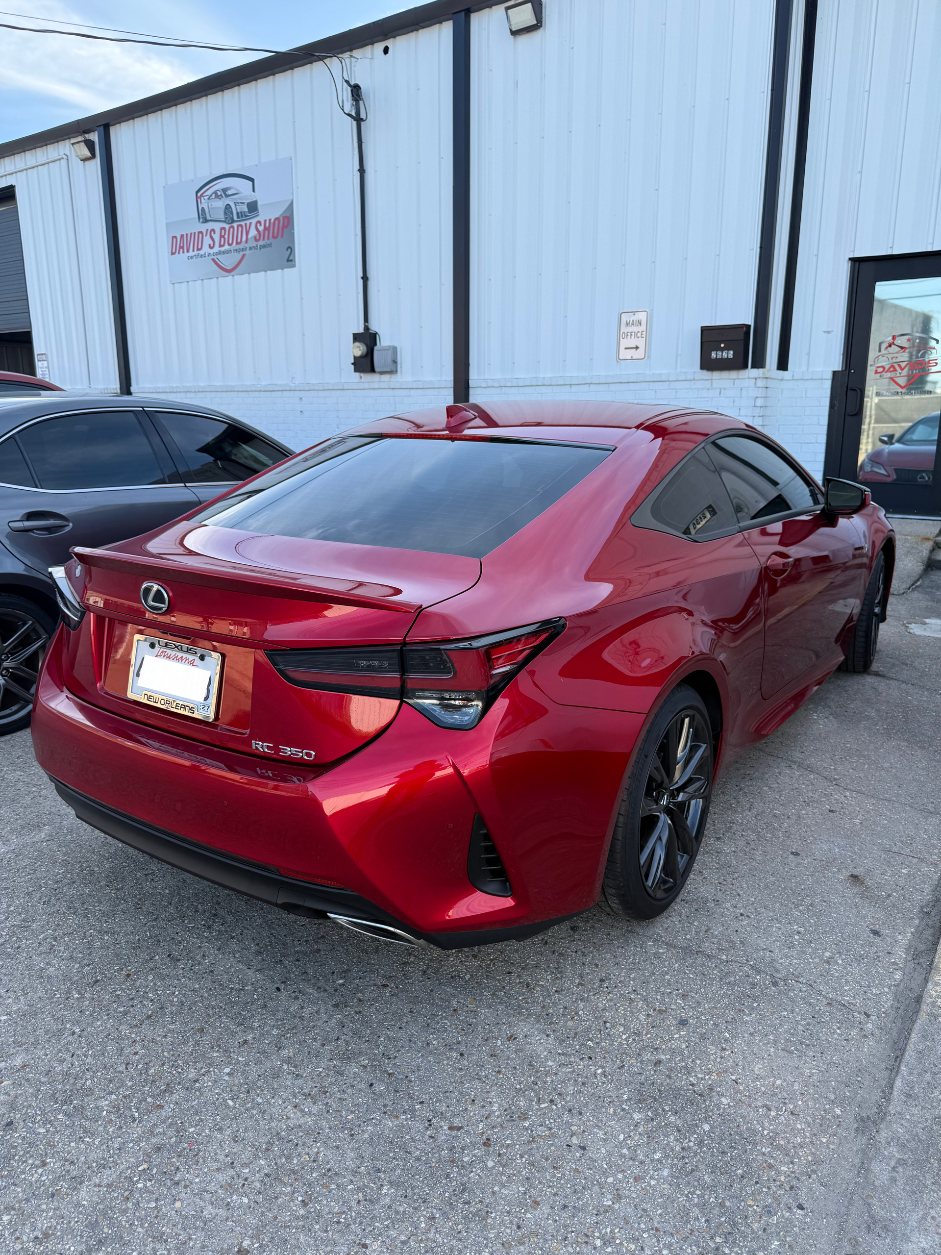 Red Lexus RC coupe parked outside a building.