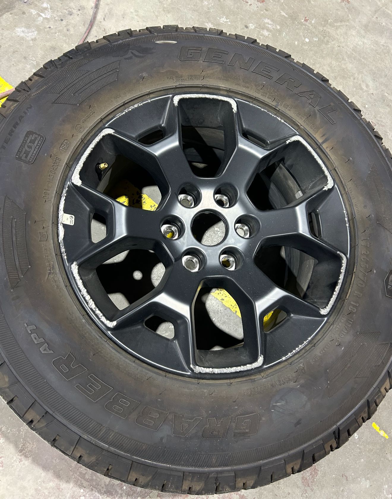 Black car wheel with silver accents and a black tire.