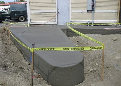 A concrete ramp is being built in front of a building