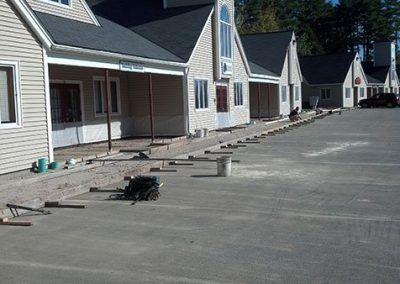 A row of houses with a parking lot in front of them