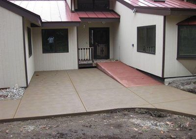 A concrete walkway leading to the front door of a house